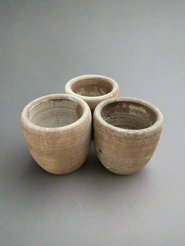 A trio of small, round, natural planters with a ridged finish.