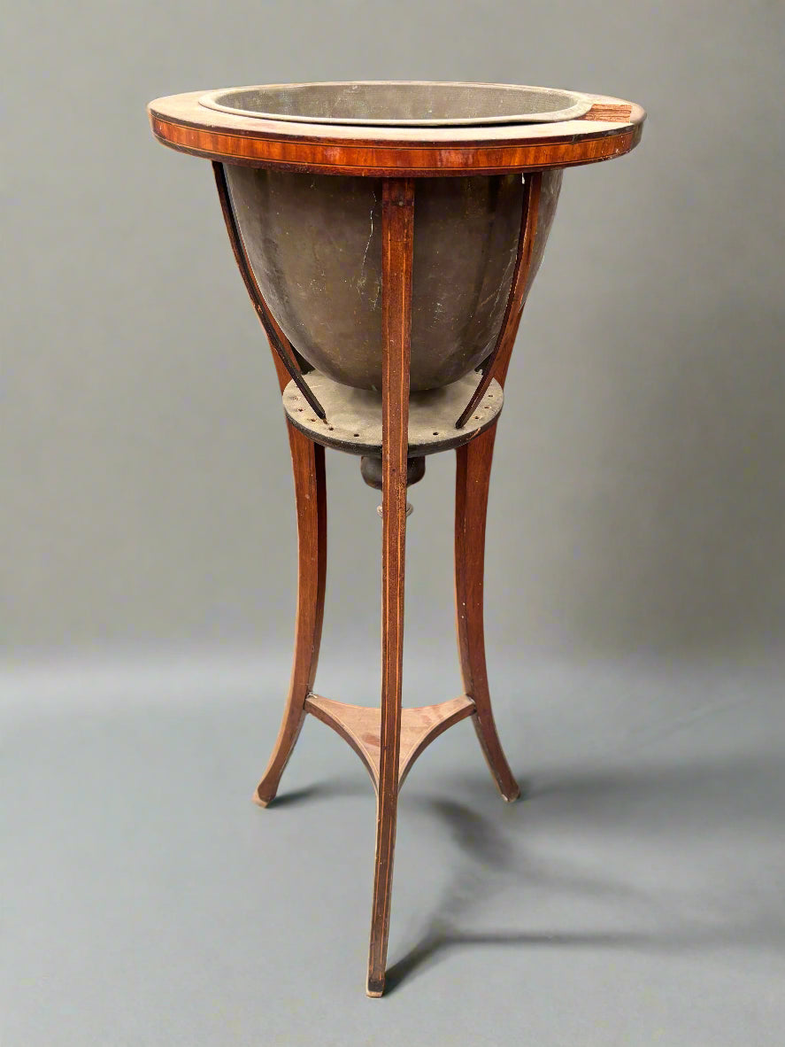 An Edwardian jardiniere with a brass liner and an inlaid mahogany frame.