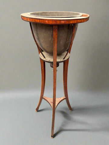An Edwardian jardiniere with a brass liner and an inlaid mahogany frame.