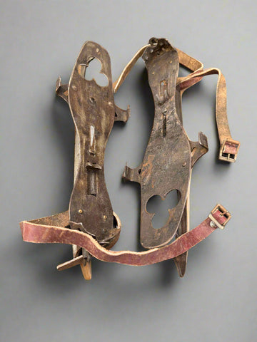 Vintage European ice skates with leather straps and an adjustable metal base, circa mid 20th century.