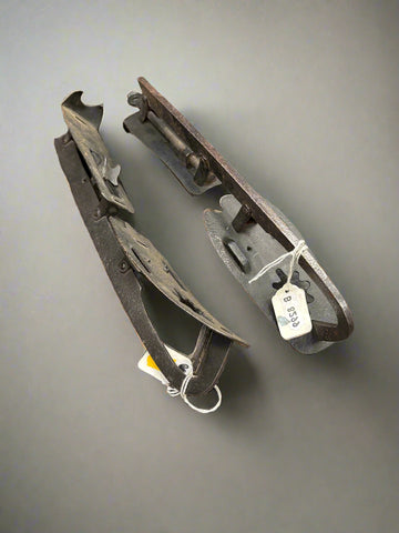 A pair of adjustable, vintage, black metal ice skates.
