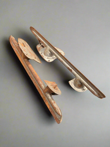 A large pair of rusty vintage ice skate blades with an adjustable base.