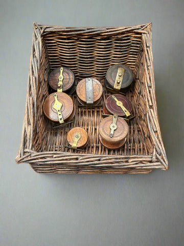 A collection of small, antique, wood and brass fishing reels.