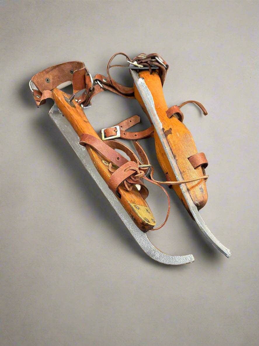 Antique Dutch wood and brass ice skates with buckled leather straps and laces.
