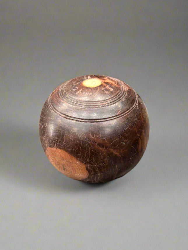 An antique English wooden bocce ball/ lawn bowling ball.