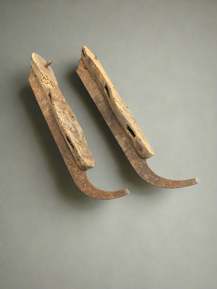 A pair of very aged, antique, wooden ice skates.