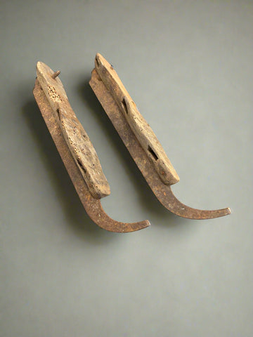A pair of very aged, antique, wooden ice skates.