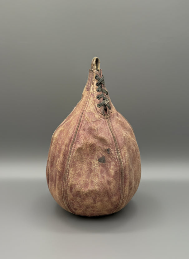 A small, vintage, leather, speed punching bag with a lace up front, circa 1930s-40s.