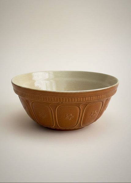 A pair of Hartley's stoneware mixing bowls with a mid brown glaze, circa 1930s. They're moulded on the outside with panels featuring a centre flower design.