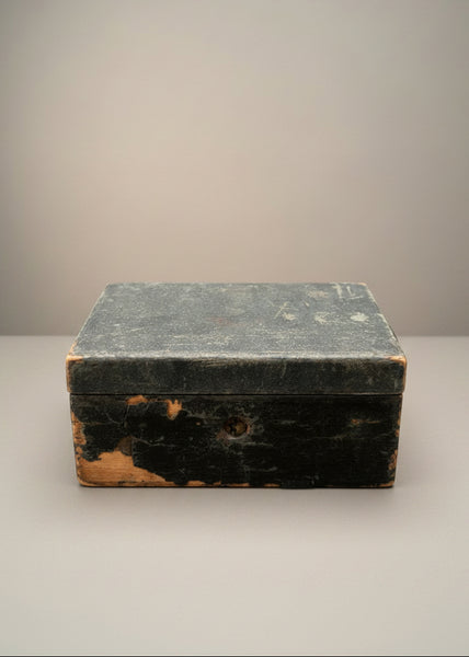 A small antique red-lined storage box with a cracked cover.