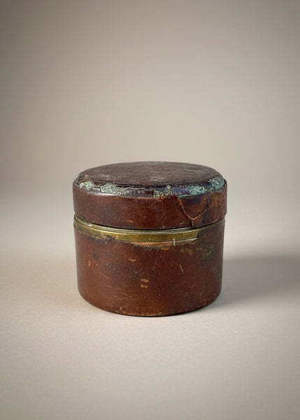 An antique Victorian travelling inkwell with an engraved brass and leather case.