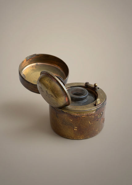 An antique Victorian travelling inkwell with an engraved brass and leather case.