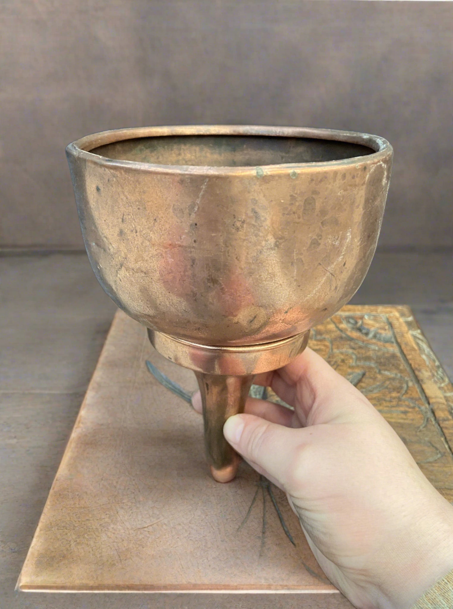 Antique copper funnel with a thick spout. It could have been used in the kitchen or brewery or for funnelling fuel or oil into a vehicle.