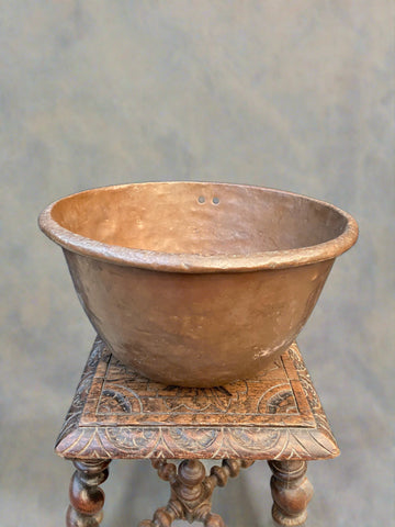 Extra large antique copper mixing bowl with a rolled edge and uneven finish.