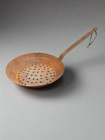 Vintage iron chestnut roasting pans. A deep sided pan for roasting chestnuts on open fires or outdoors. It has a hole at the end of the handle to hang on the fireplace in the hearth.