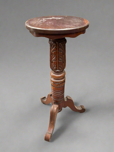 A matching pair of plant display pedestal tables with heavily carved stems.