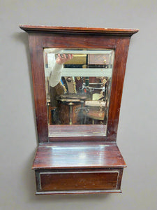 Antique wall-mounted rectangular mirror with a storage box.