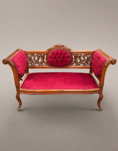 A Victorian-style carved mahogany setee with crimson pink upholstery.