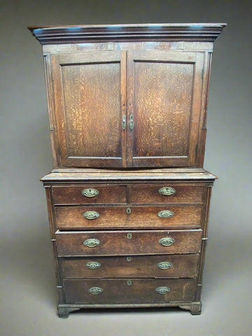 Double door antique wooden dresser with six drawers and oval shaped brass hardware.