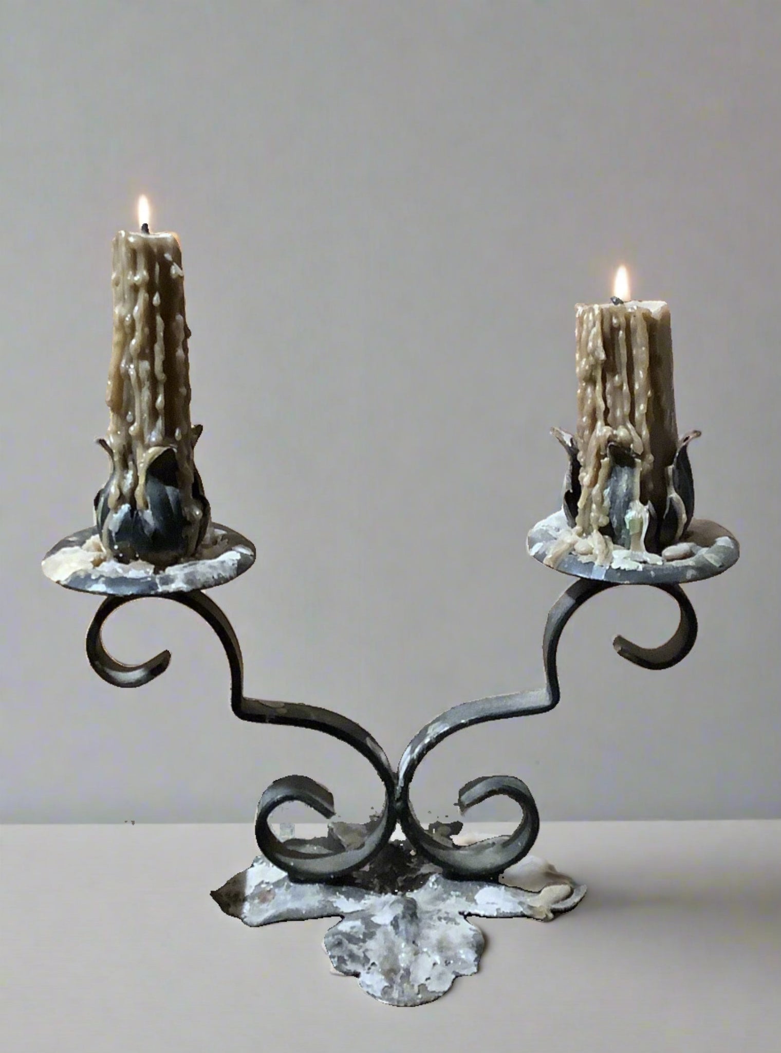 Antique wrought iron tulip-shaped double candle holder.