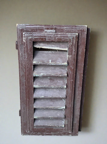 Small brown painted window shutters, in an aged condition.
