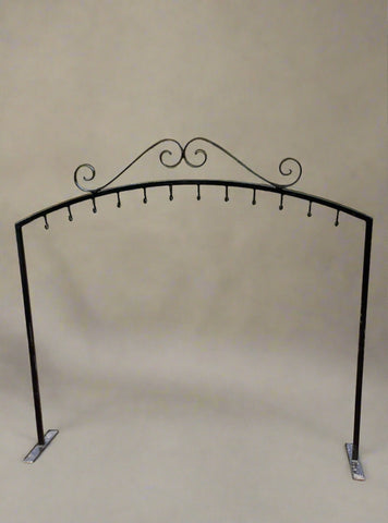 Free-standing wrought iron frame with twelve hooks.