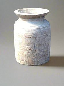 Painted wooden vase with a ridged and worn exterior.