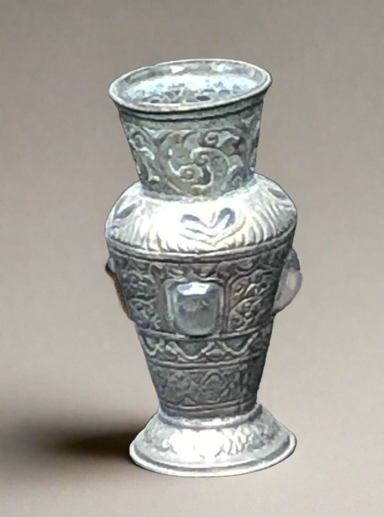 Ornate moulded pewter vase with a tall neck and extruding glass gems.