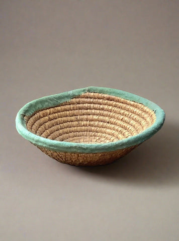 Woven basket bowl with green fabric trim.