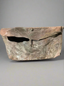 A large rough leather saddle bag in an aged condition.
