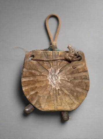 Unusual carved wooden cowbell, tied with jute rope.