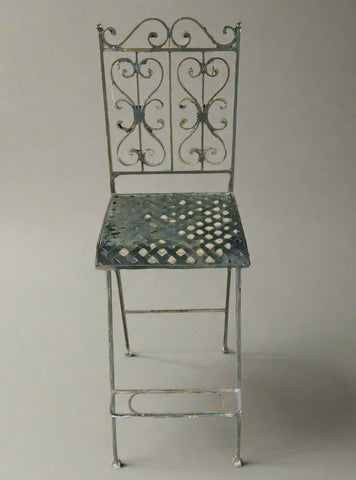 Victorian-styled folding wrought iron garden chair, with a footrest.