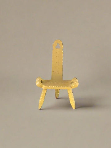 Yellow three-legged stool with a narrow back and two side handles.