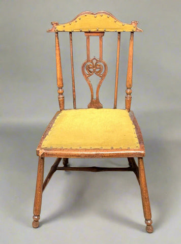 A set of antique wooden chairs, upholstered in a mustard-coloured fabric.