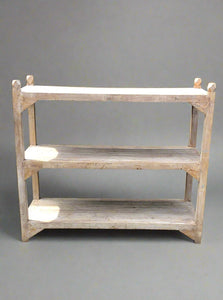 Light coloured wood shelving rack with three shelves for storage.