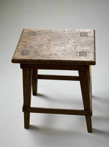 A set of rustic square wooden stools.