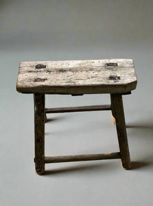 A set of small rustic rectangular wooden stools.