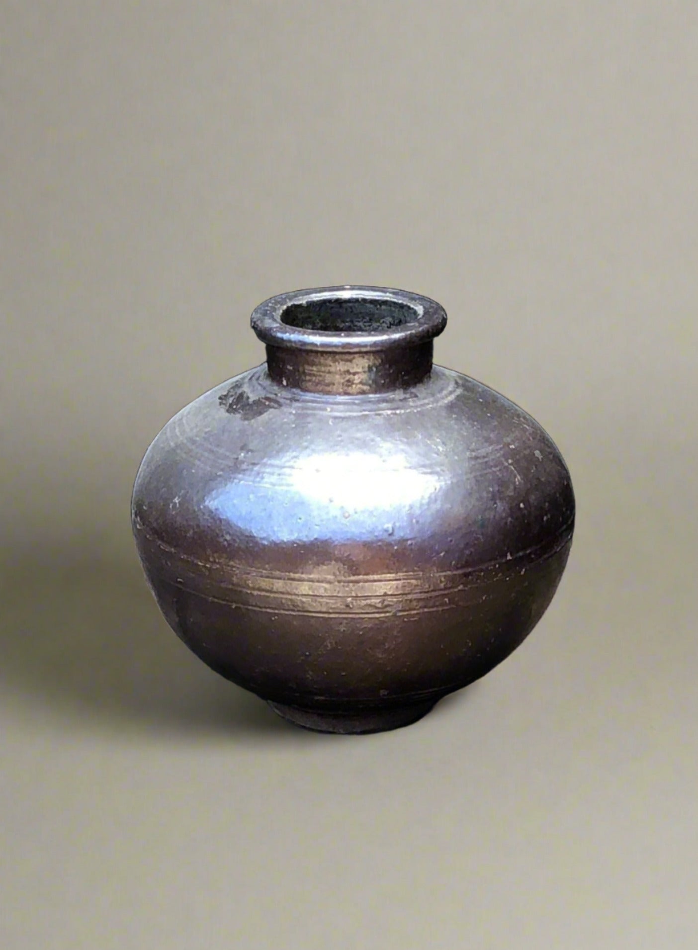 Brown glazed ceramic vase with a narrow neck and round body.