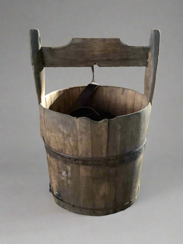 Vintage wooden well bucket with metal banding.