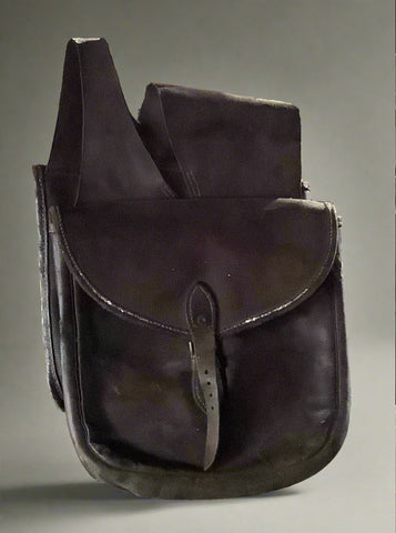 Brown leather saddle bag with a buckled close and carrying strap.