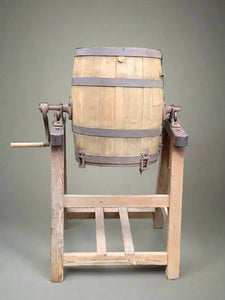 Wooden barrel butter churn and stand, used to convert cream into butter.  The barrel churn was used in Europe from the 18th century.