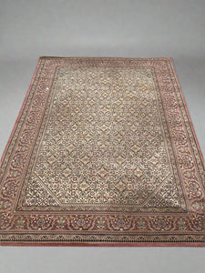Large traditional rug woven with red and cream thread in geometric and floral patterns.