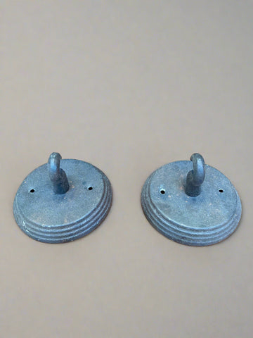 Two grey metal wall hooks on a round base.