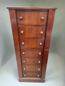 Tall seven-drawer wooden unit with folding side panels that can be locked.