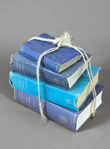 Stack of traditional blue hardback books, bound with jute string.