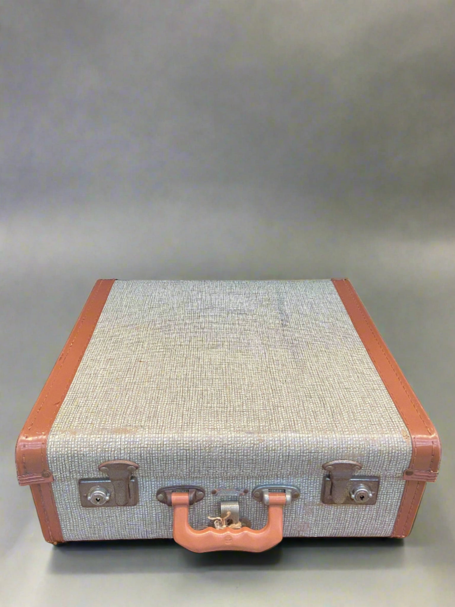 1960s-style tan and grey suitcase with a fine chequered pattern.