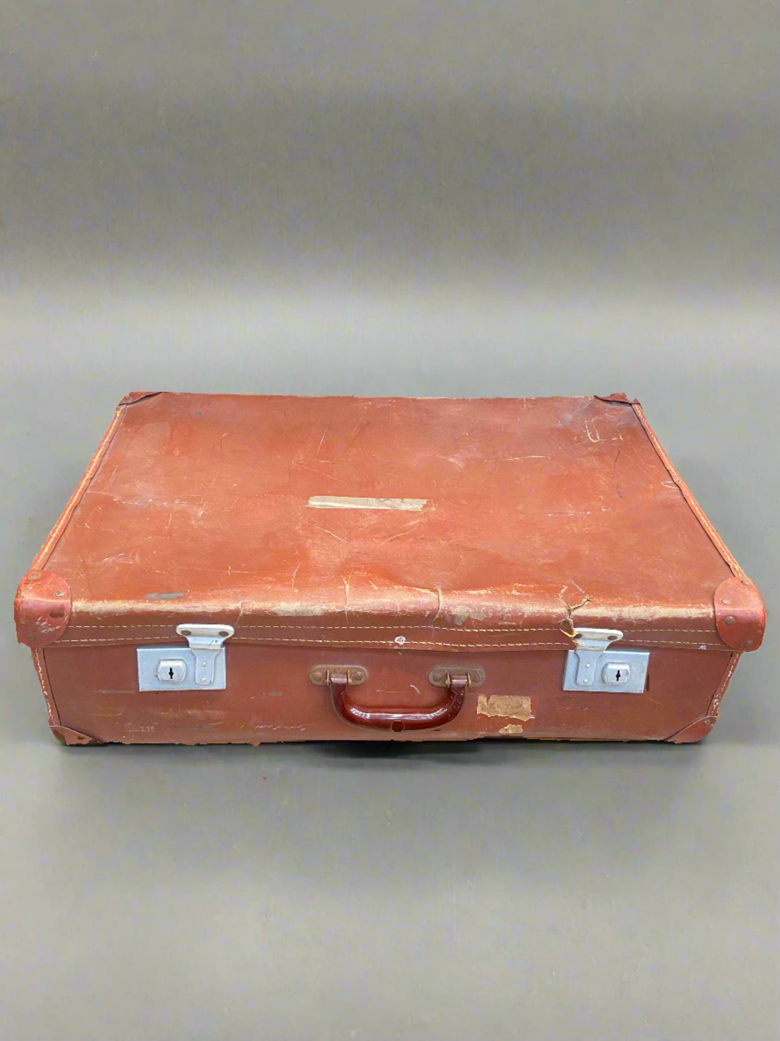 Red-brown coloured leather suitcase with a shiny chestnut brown handle.