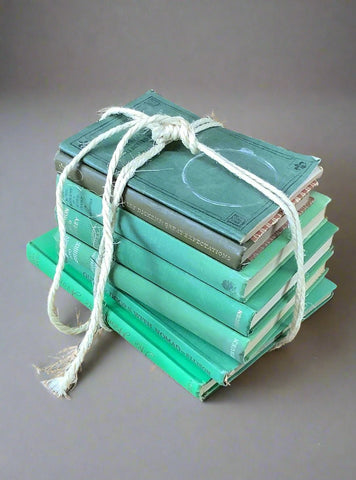 Stack of traditional hardback green books, bound in jute string.