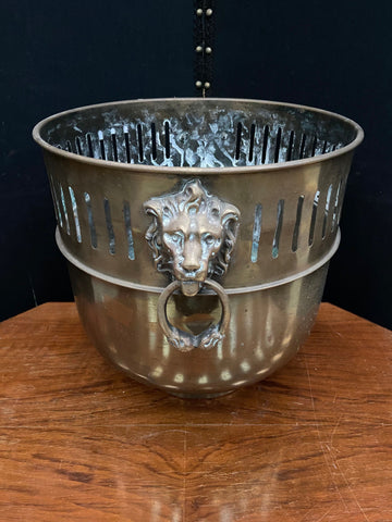 Round brass coal scuttle/bucket with two 'doorknocker style design' lion heads forming handles.