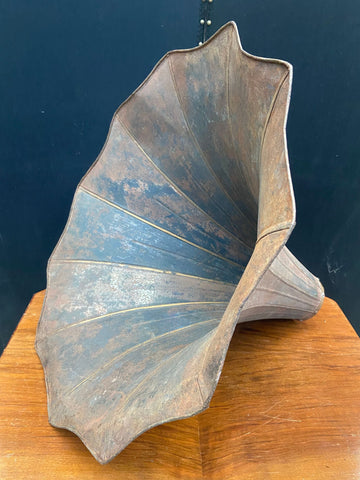 Navy-coloured gramophone horn with a rusty patina.&nbsp;